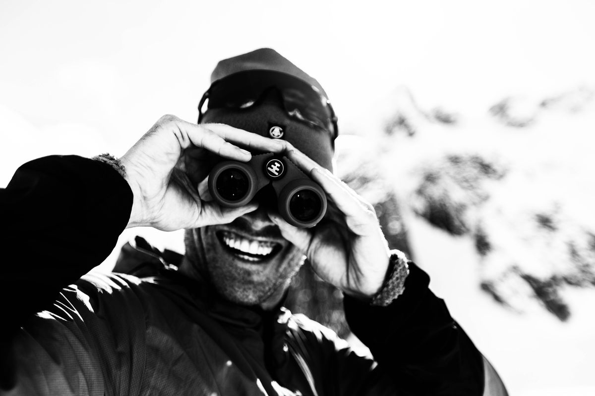 Black and white portrait of a mountaineer looking through binoculars