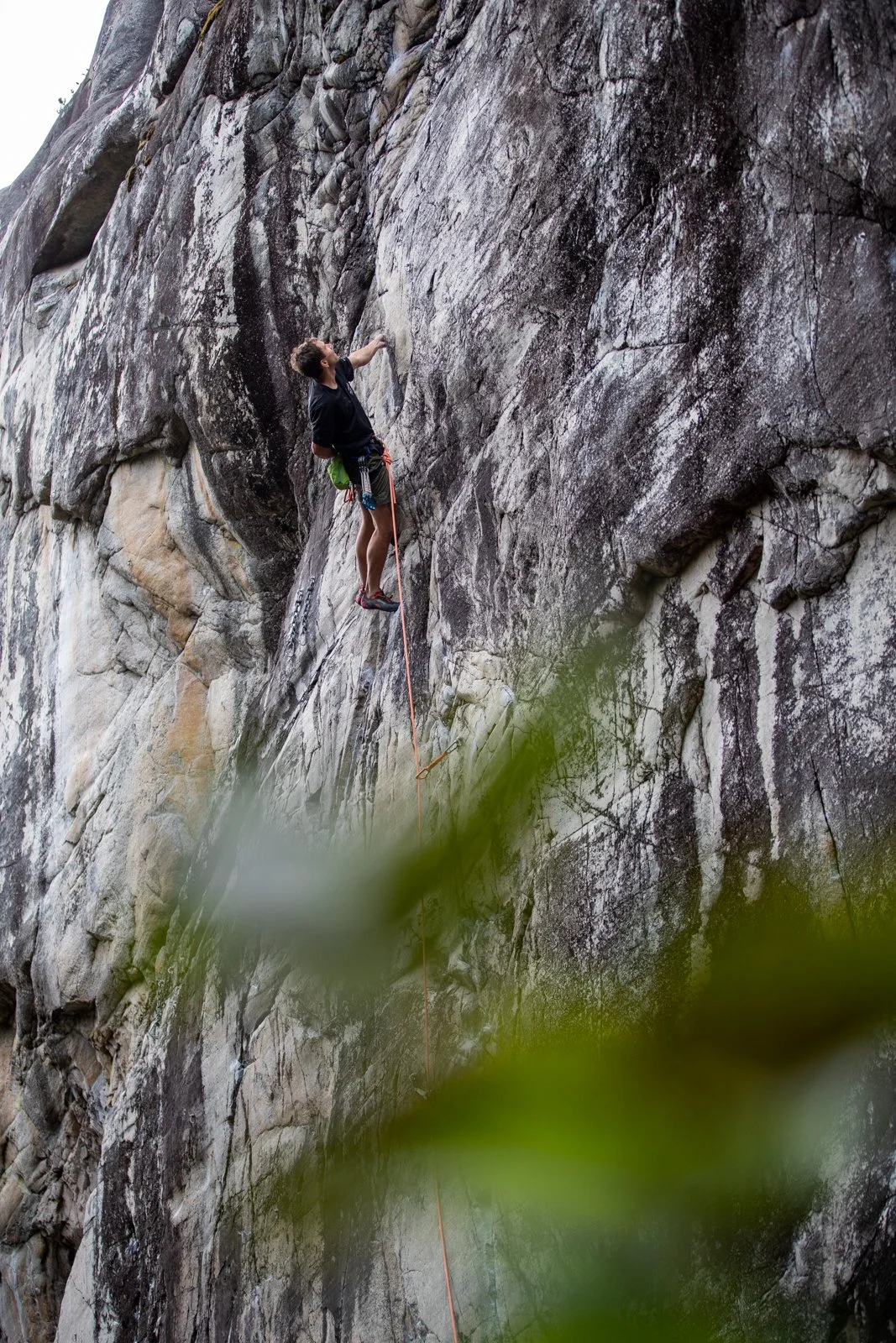 Climber celebrating at summit with panoramic Squamish valley views