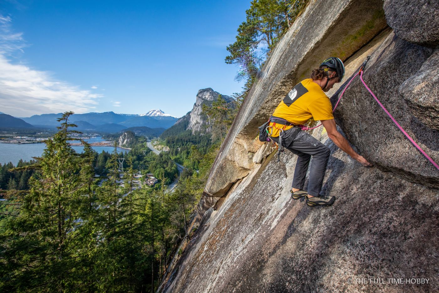 Rock climber on a granite wall above Howe Sound in Squamish, BC